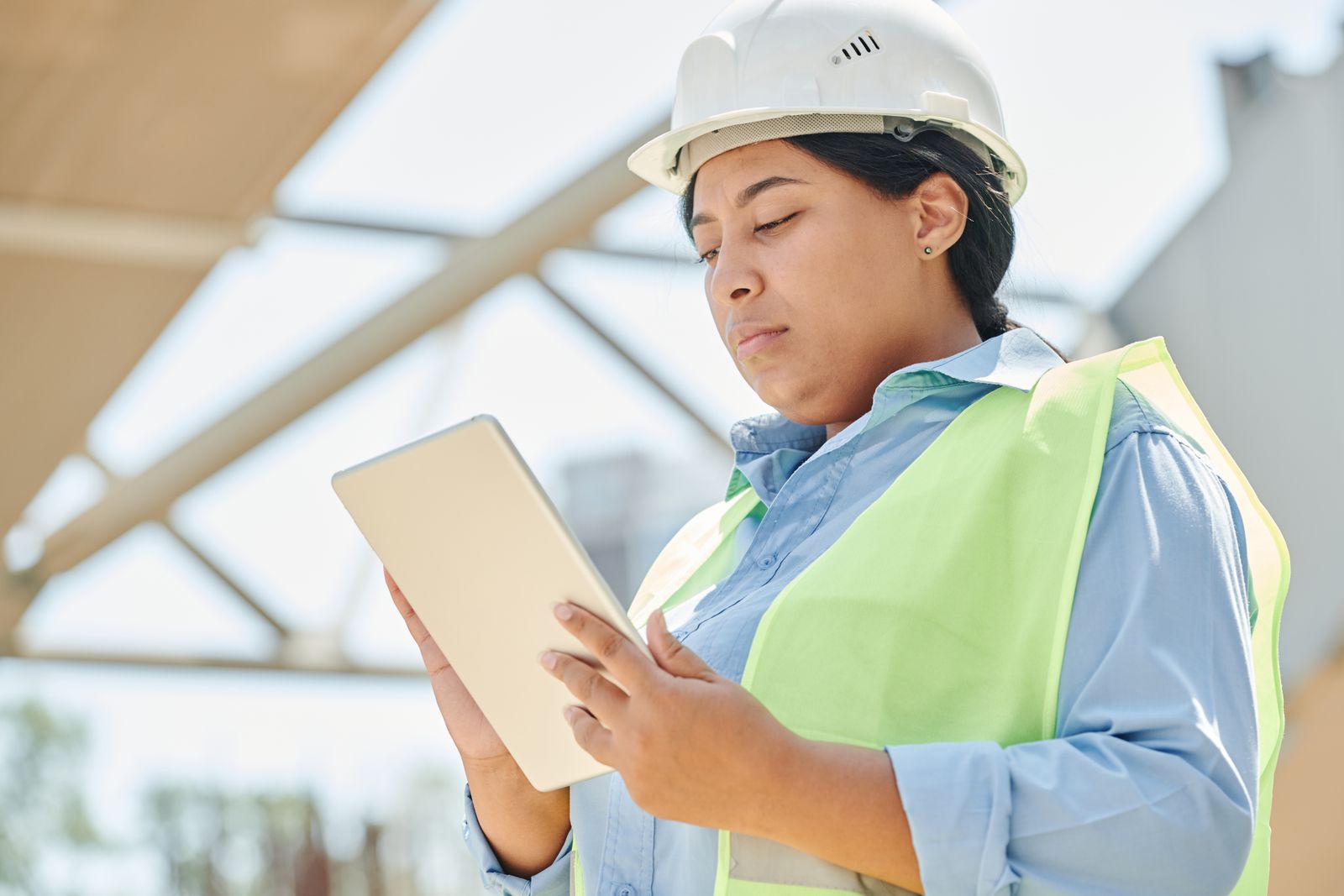 A contractor on a jobsite using a tablet